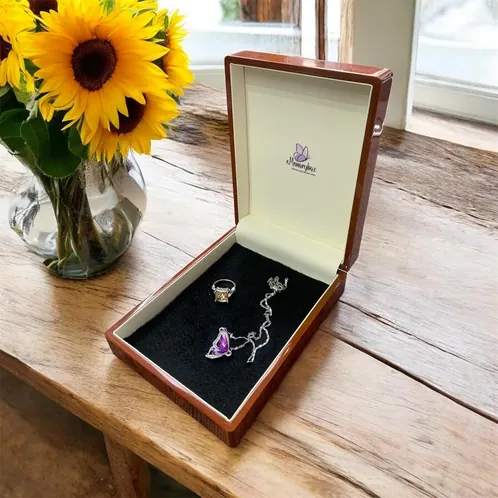 Open walnut eMemorybox with a ring and necklace inside, sunflowers behind